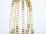 un collier de perles à trois rangs muni d'un fermoir en or