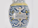 a blue and yellow vase with a name on it