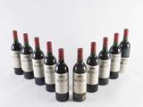 six bottles of wine lined up in a row on a white surface
