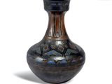 un vase noir orné de motifs bleus et marron