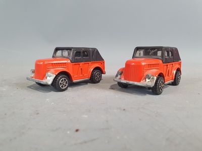 two toy cars sitting next to each other on a white surface