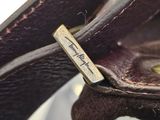 a close up of a brown leather purse with a name tag on it