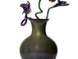 a black vase with flowers in it on a white background