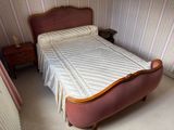 a bed with a quilt on top of it in a room