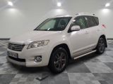 the white toyota suv is parked in a large room