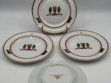 a set of four plates and a bowl with a bird on it