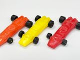 trois voitures jouets qui sont assises l'une à côté de l'autre