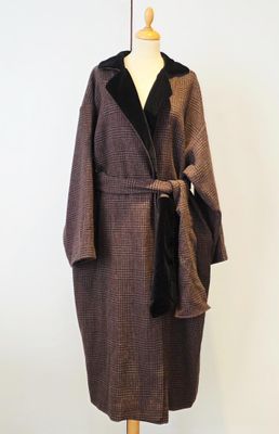 manteau marron et noir sur un pied de mannequin, avec une écharpe noire