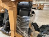 a pile of luggage sitting on a cart in the middle of a room