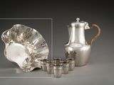 un service à thé en argent composé de quatre tasses et d'une théière