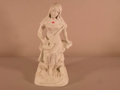 une statue blanche représentant une femme avec une croix rouge sur la poitrine
