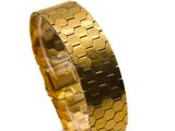 gold plated bracelet with hexagons on a clear acrylic stand