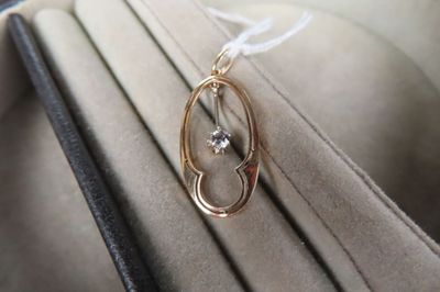 Pendentif ovale ajourée en or jaune 14K (585/1000e) orné d'u…