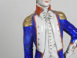 a figurine of a man in a blue and white uniform