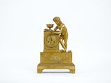 an image of a gold clock with a man on top of it