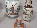 three vases and a box are sitting on a white surface