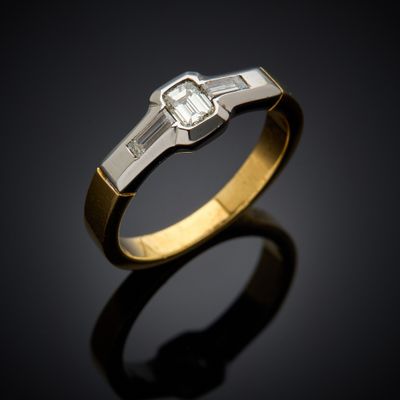 an engagement ring with a baguet cut diamond set in 18k yellow gold