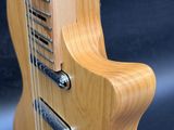 a close up of a guitar with a wooden body and strings