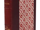 un vieux livre à la couverture rouge posé sur une surface blanche