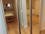 une personne en train de prendre une photo d'un miroir dans une pièce