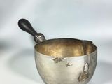 a silver bowl with a black handle on a white background