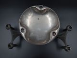 a silver bowl on a black background with three metal legs