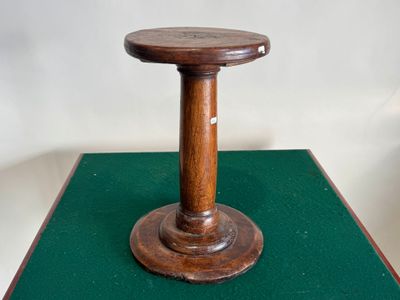 une petite table en bois avec un plateau en bois posé sur un revêtement vert