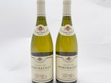 deux bouteilles de vin blanc posées l'une à côté de l'autre sur une surface blanche