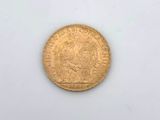a close up of a gold coin on a white surface