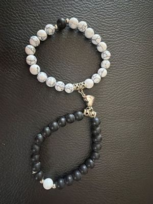 a black and white beaded bracelet with a skull charm