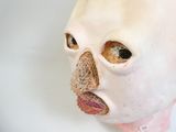a white mask with a pink nose on a white surface