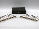 six silver plated spoons and a box on a white surface