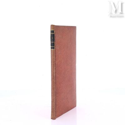 an old book with a brown cover sitting on top of a white surface