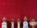 cinq vases posés sur une table, avec un mur rouge en arrière-plan