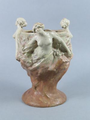 a small vase with a statue on top of it