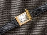 une image représentant une montre dorée et noire sur fond noir