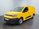 une camionnette jaune garée dans une pièce au sol noir