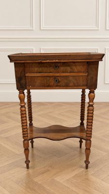 une vieille table en bois surmontée d'un tiroir, posée sur un parquet en bois massif