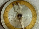 une horloge argentée et dorée posée sur un fond blanc