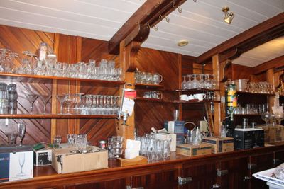 un comptoir en bois sur lequel sont posés de nombreux verres
