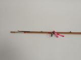 a pink ribbon tied to a fishing rod on the wall