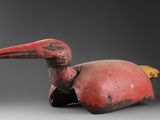 une photo représentant une statue d'oiseau rouge posée sur une table