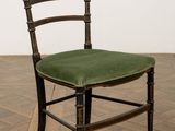 une chaise en bois avec une assise verte posée sur un parquet
