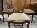 three chairs with cane back and cane back cushions in a room