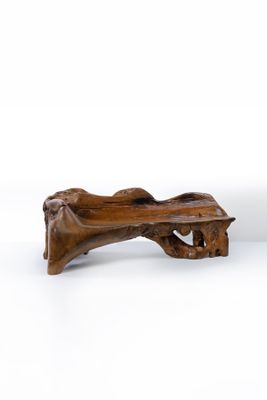 un banc en bois posé sur une surface blanche