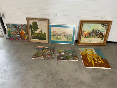 de nombreux tableaux posés par terre dans une pièce