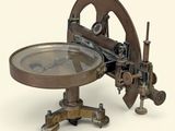 une machine qui a l'air très ancienne, sur laquelle est posée une loupe