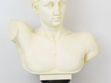 un buste d'homme en marbre blanc posé sur un socle noir