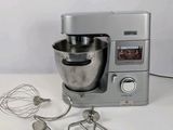 a silver mixer and a whisk on a white table