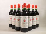 six bouteilles de vin rouge alignées sur une surface blanche